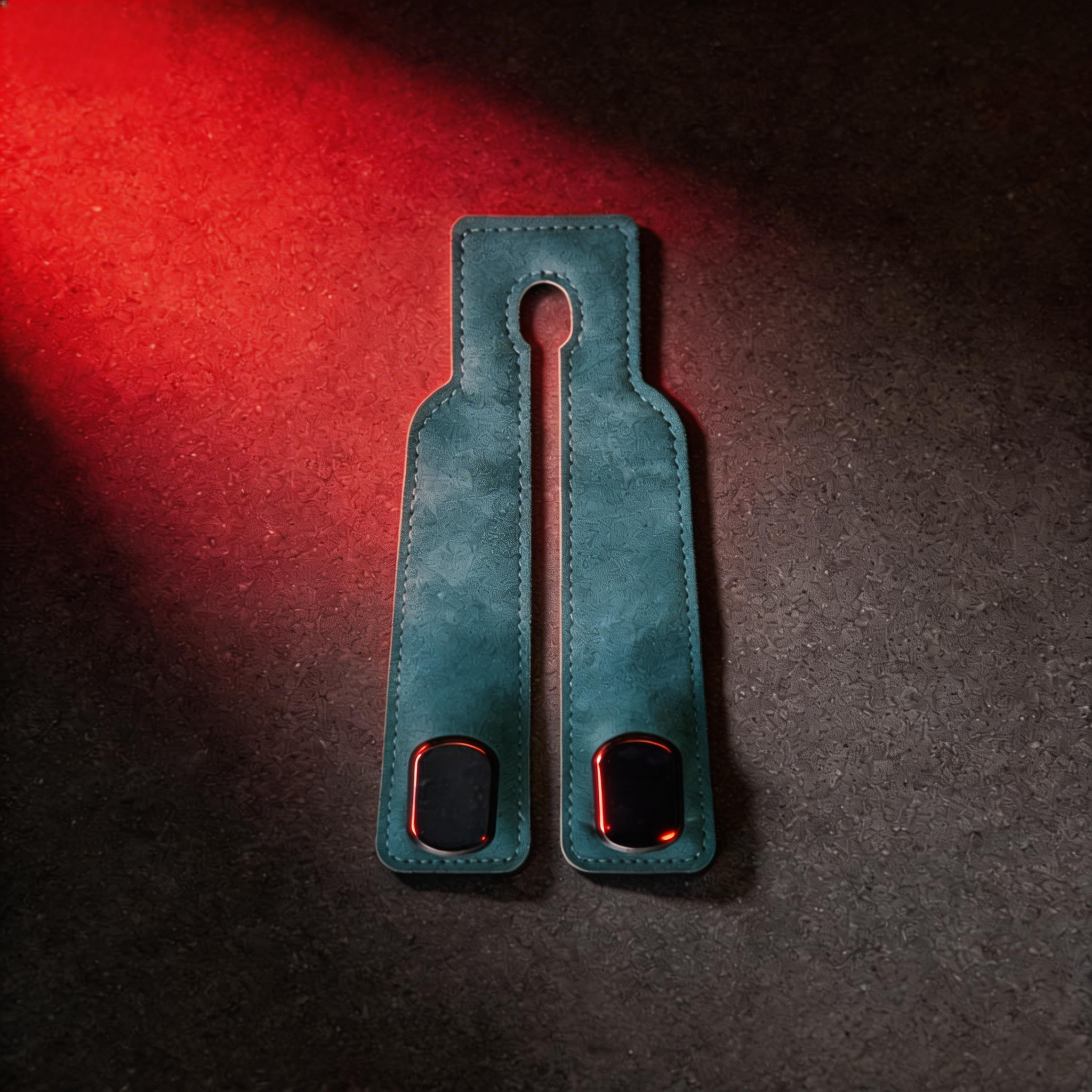 Emerald green suede car headrest hook with dual black and red clips on textured surface